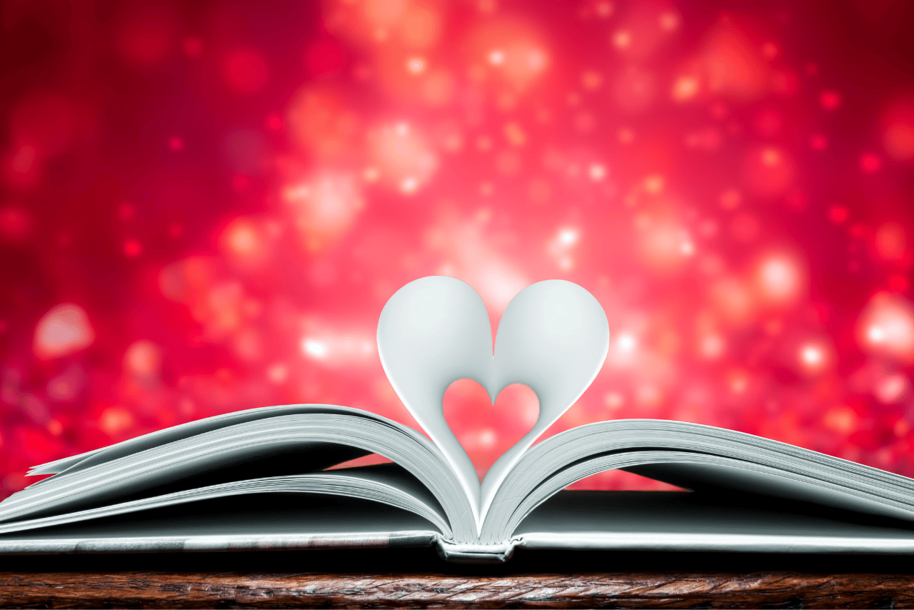 book laying open with 2 pages forming heart with a red sparkly background