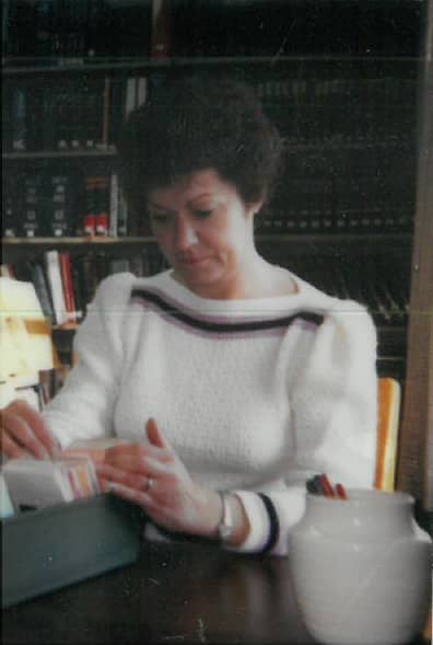 woman sitting at desk looking through cards