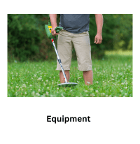 man standing in grass with a metal detector